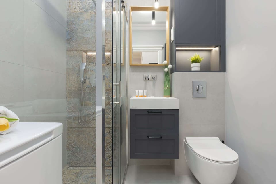 A bathroom showcasing a glass-enclosed shower, modern fixtures, and elegant tiling.