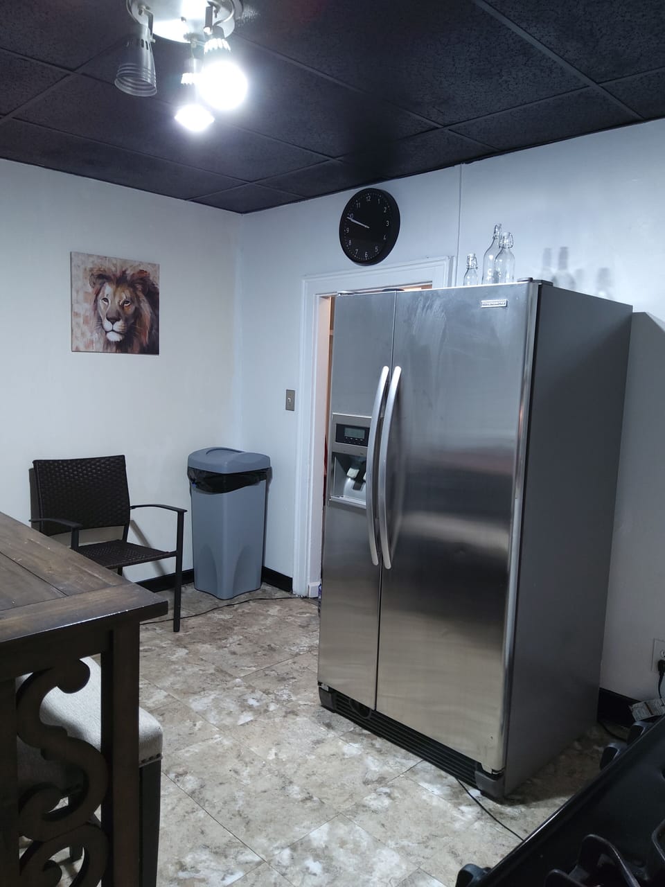 Wall clock above entrance and trash can