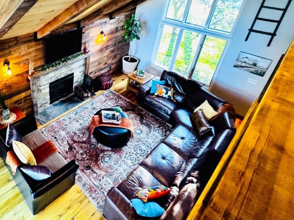 Charming living room with high vaulted ceilings and abundant windows, allowing you to soak in the surrounding scenery 