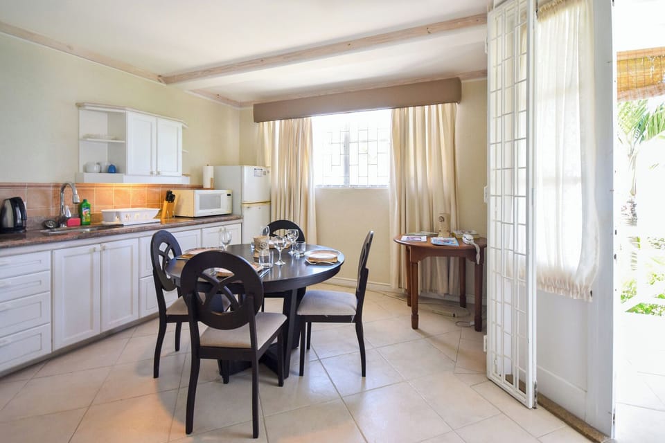 Open plan kitchen and eating area - window and patio open up to the sea