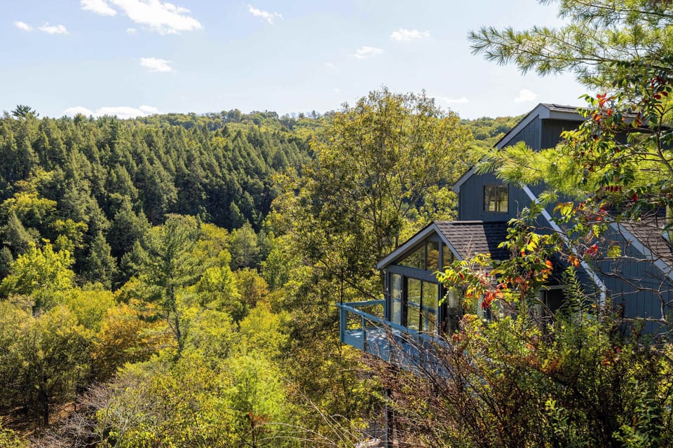 Lean on the railing and stare into the treetops — the wooded hillside view from this deck is exactly what you came here for.