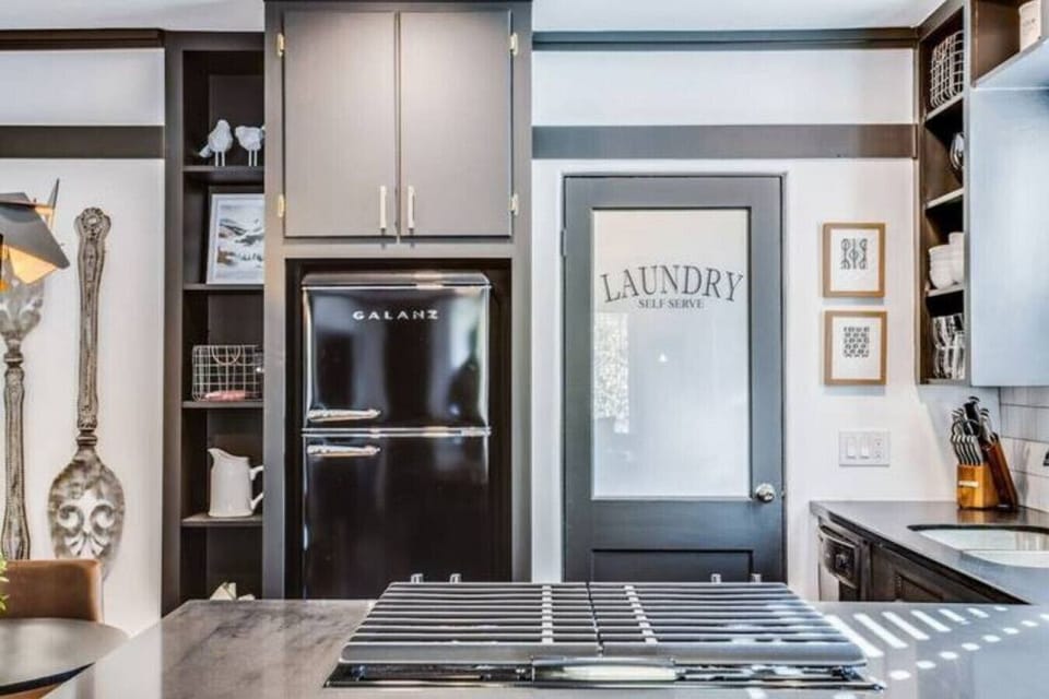 Stylish kitchen with dark cabinets and a clean tiled backsplash.