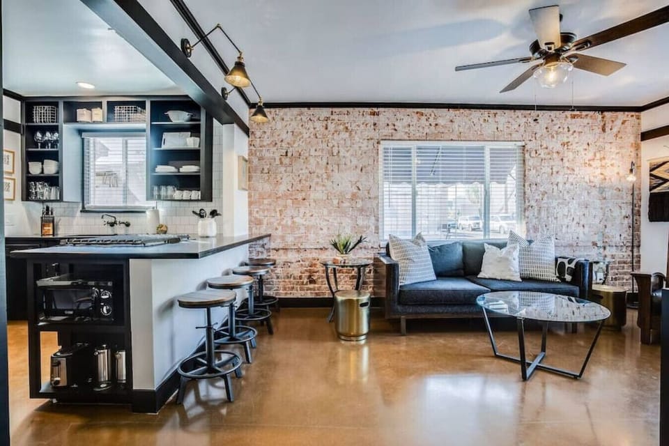 Modern kitchen and living combo with exposed brick and a roomy island.