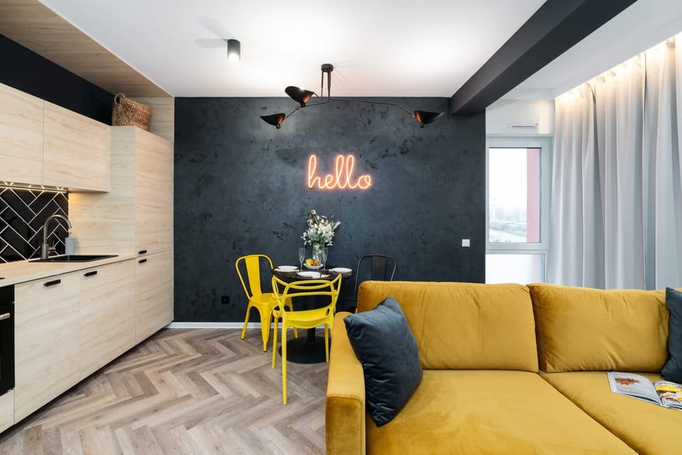 A second angle of the living room, highlighting the yellow sofa, curtains, and bright natural light.