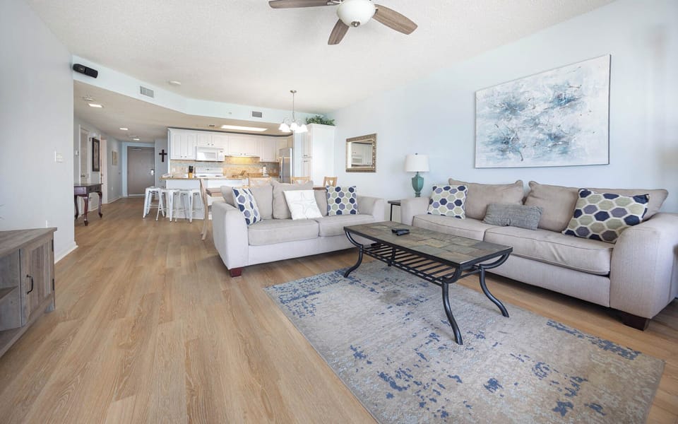 Relax in the spacious living area featuring a sofa with queen sleeper, stylish decor, and a welcoming coastal vibe