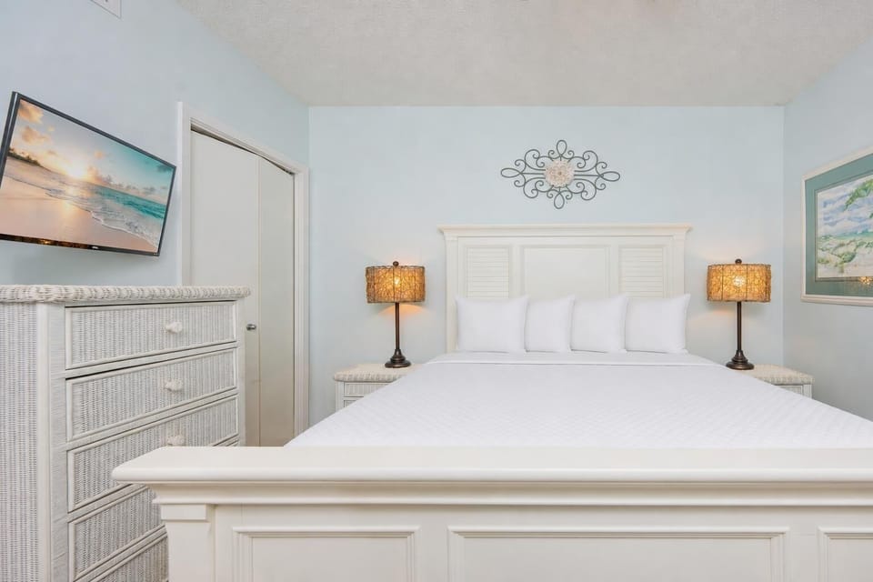 Queen bed in the guest suite invites you to rest beneath warm lamps glowing softly on each side