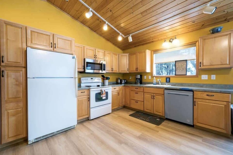 Fully equipped kitchen with cooking basics, spices, drip coffee maker, dishware/flatware, paper towels/trash bags blender, and toaster.