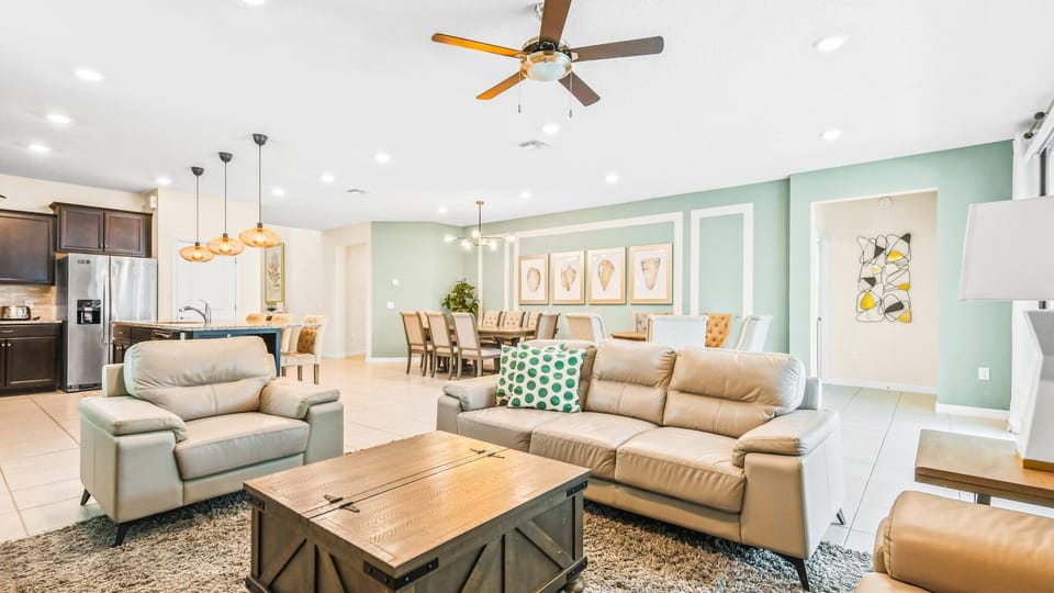 Open-concept living space with comfy seating, elegant dining area, and modern kitchen island lighting.