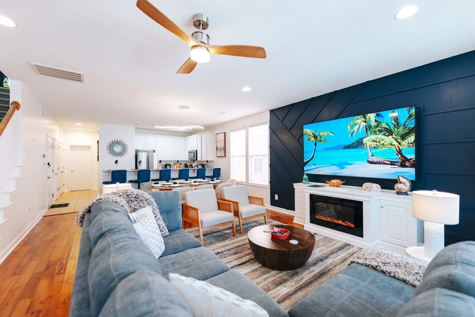 [Living Room] The brightly lit living room has plenty of seating for everyone in your group and is right off the kitchen/dining area, embracing open-concept design. #AmazingDecor #luxuryliving #moderndesign #VacayMode #SunnyEscapes #BeachTherapy