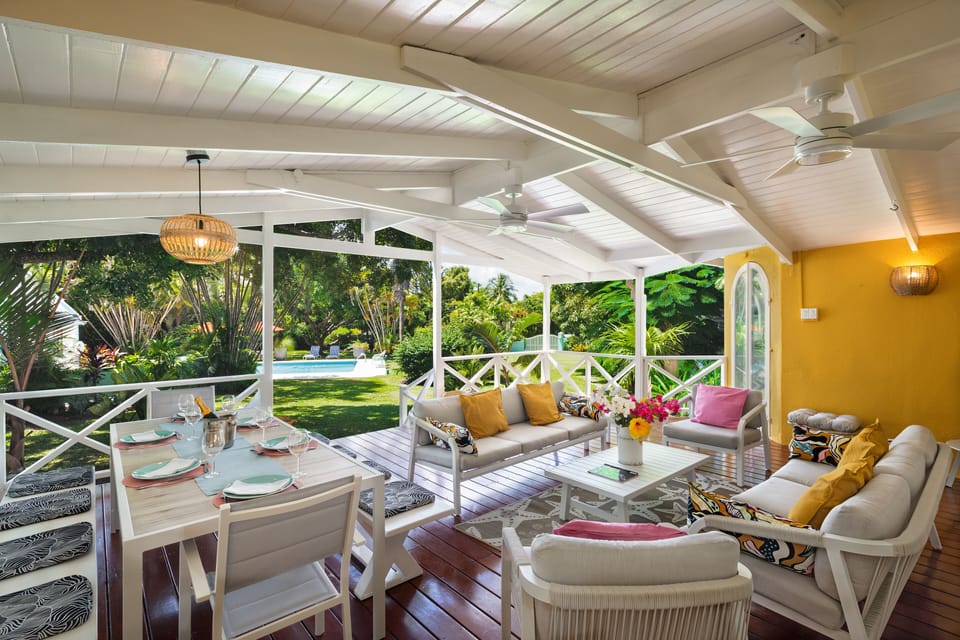 The main deck has a tropical wooden floor and looks out to the garden & pool