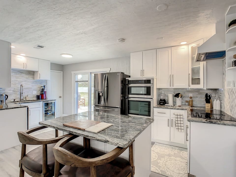 Contemporary kitchen with granite island, stainless steel appliances, and ample cabinet space.