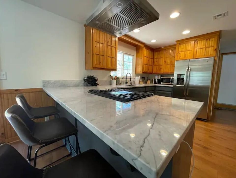 Fully stocked kitchen with white marble counter tops and breakfast bar