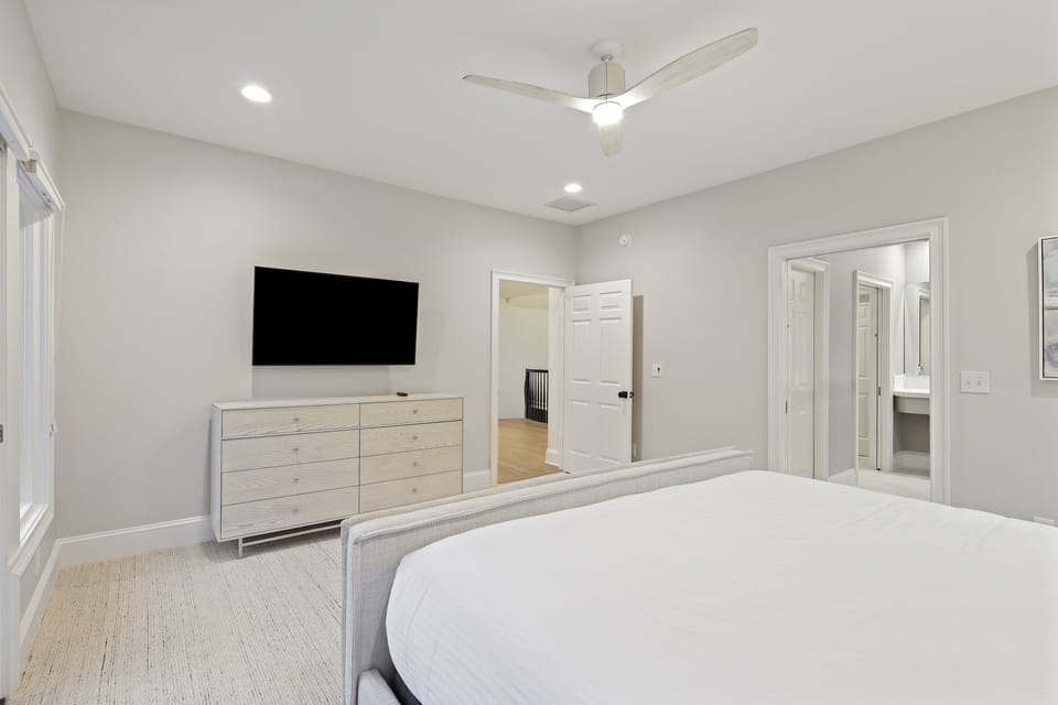 Primary bedroom upstairs with king bed, TV, en-suite, and private deck.