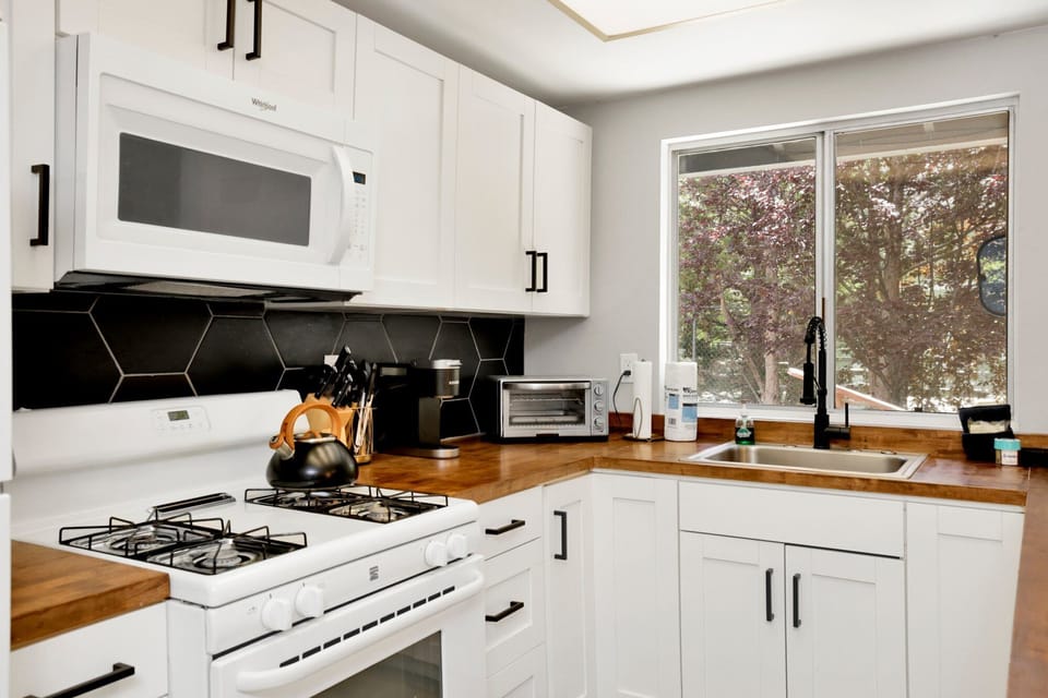 Fully equipped cabin kitchen with ample cabinetry, stove, fridge, microwave, and coffee maker—perfect for cooking meals, morning coffee, and feeling right at home on your stay.