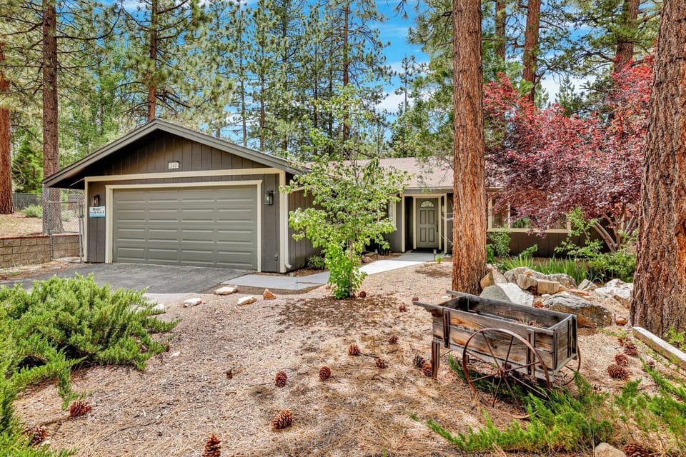 Welcoming cabin entry surrounded by towering pine trees, offering fresh mountain air and a peaceful forest setting—the perfect first impression for your Big Bear Lake getaway.