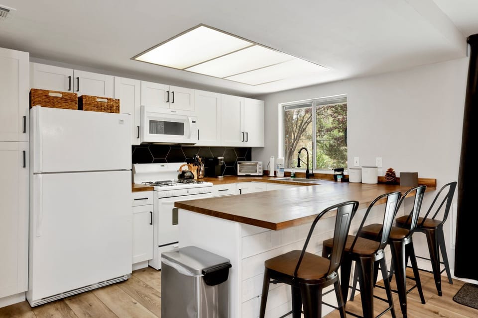 Fully equipped cabin kitchen with ample cabinetry, stove, fridge, microwave, and coffee maker—perfect for cooking meals, morning coffee, and feeling right at home on your stay.