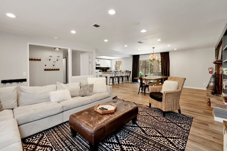 Cozy mountain living room with a stone fireplace, comfy seating, and smart TV—perfect for relaxing evenings, movie nights, and warm cabin vibes after outdoor adventures.