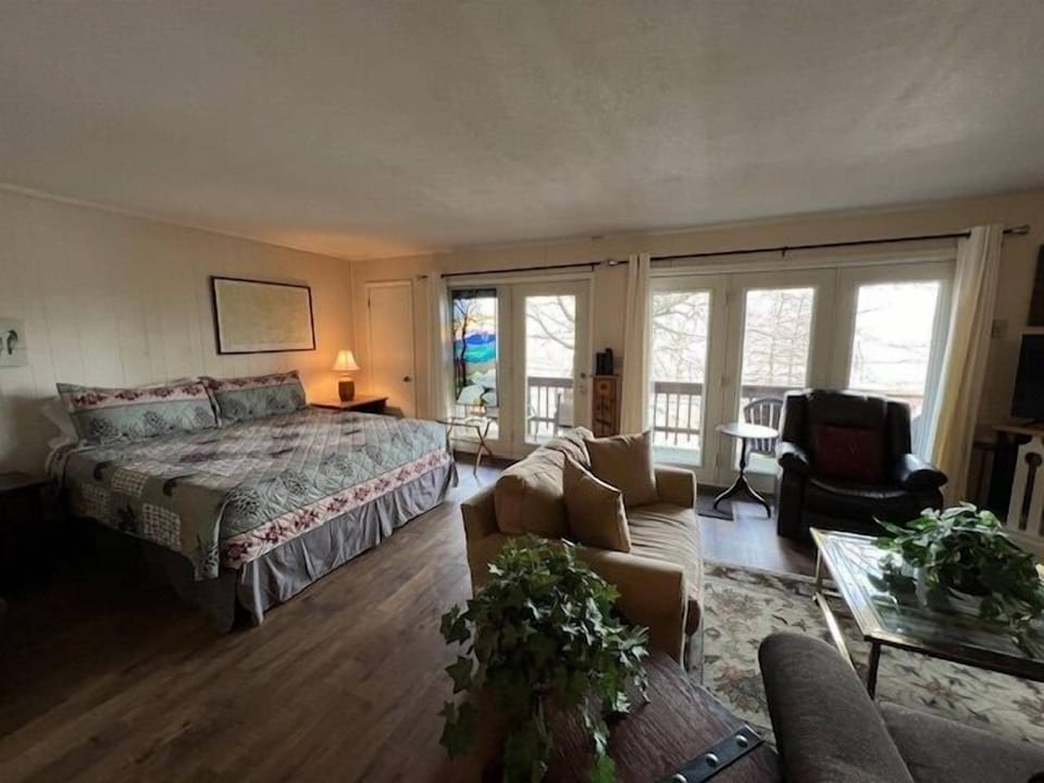 Spacious bedroom with king-sized bed, cozy seating, and balcony access.