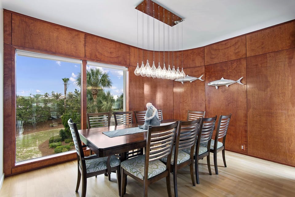 Warm wood-paneled dining area w/ large windows & a relaxed, inviting feel