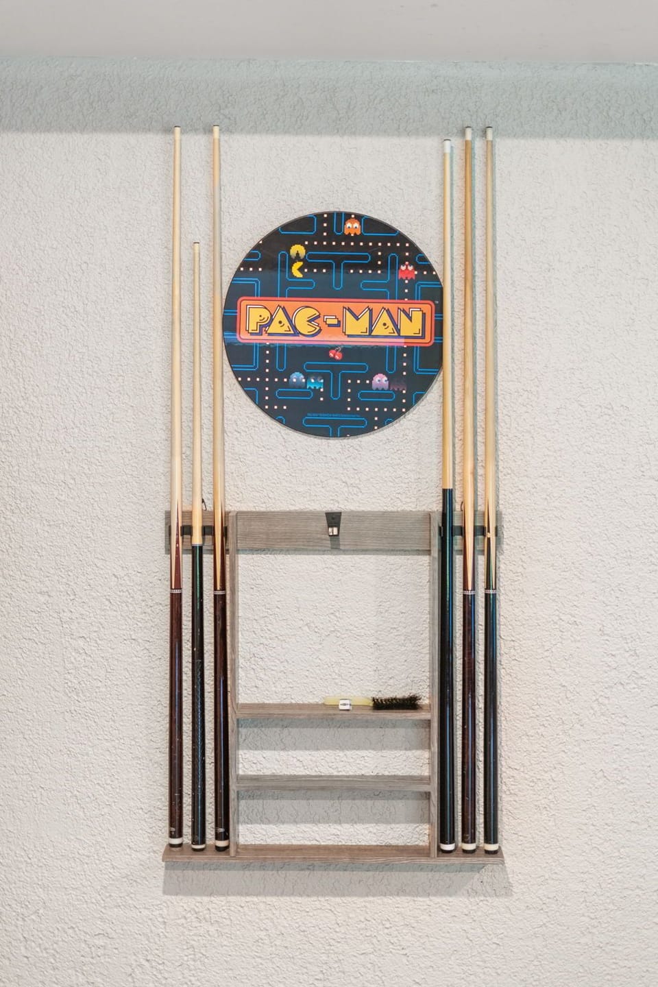 Challenge friends to a game with your personal pool cue rack featuring classic Pac-Man artwork for nostalgic entertainment.