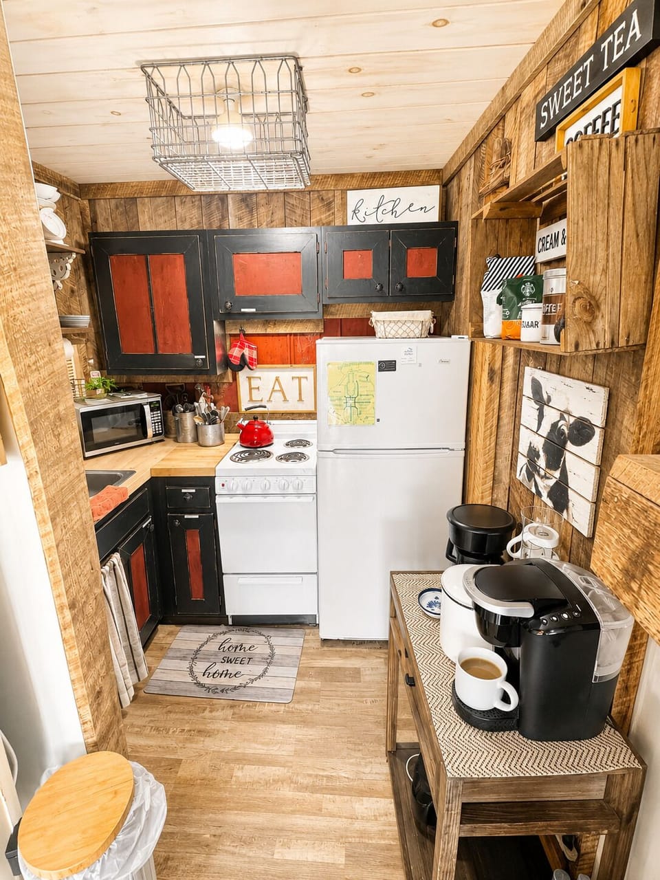 Full kitchenette with fridge, EAT sign decor, and cow-print country styling