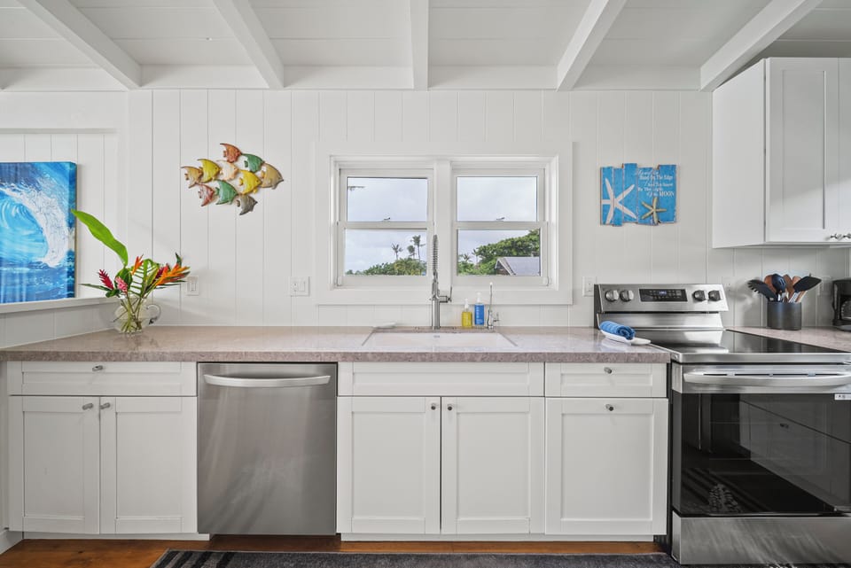 Sunny kitchen workspace framed by tropical views, offering plenty of counter space for family-style cooking.