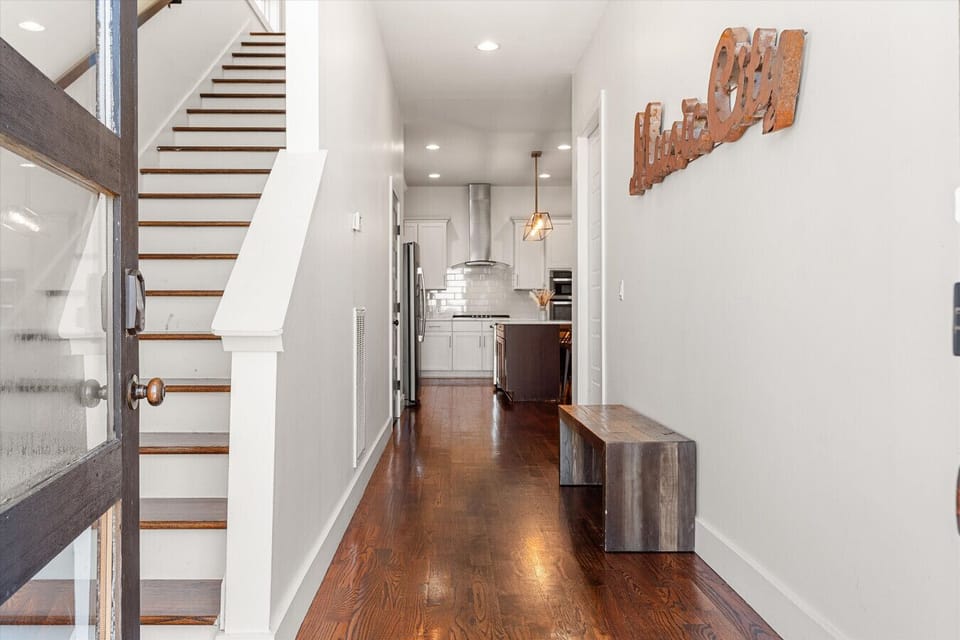 Step inside to warm lighting, rich hardwood floors, and a clear sight line straight through to the kitchen.