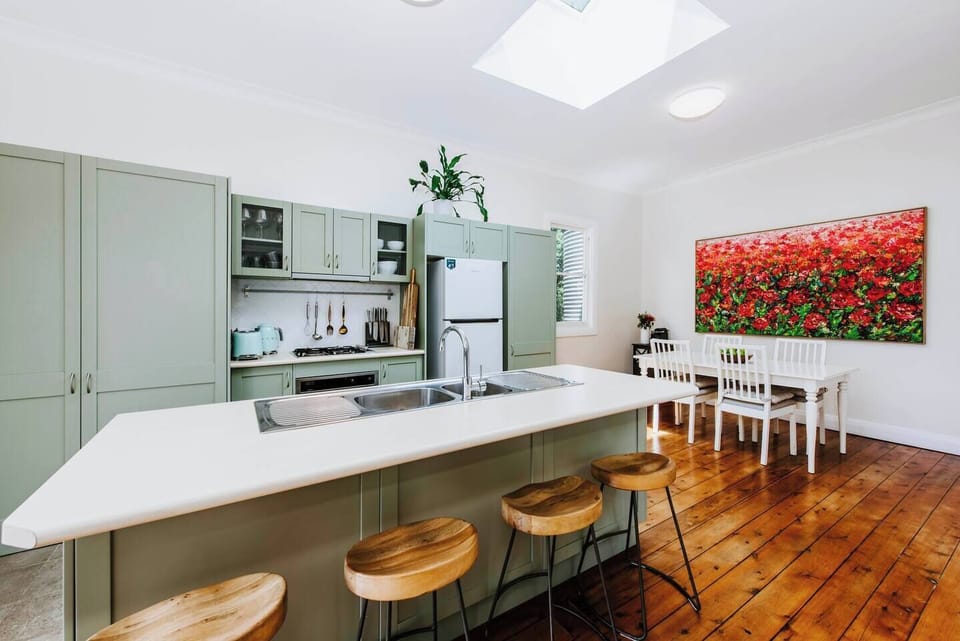 Sage cabinets compliment timber floors in the kitchen.