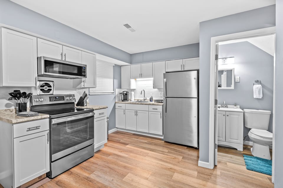 White cabinetry, stainless-steel appliances, and generous counter space create a bright, fully equipped kitchen.