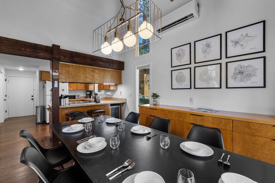Gather around this sleek dining table set for six, with custom wood cabinetry and modern finishes creating a warm, open-concept space for your meals together.