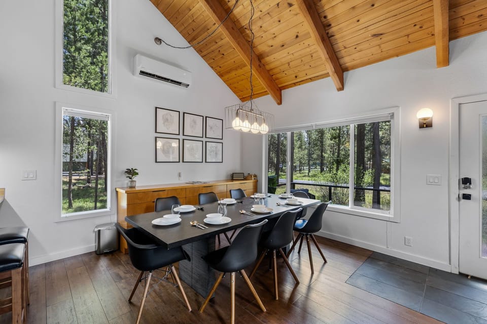 Gather around this elegant dining table with forest views framing every meal, beneath soaring wood-beamed ceilings that bring warmth and natural beauty into your mountain retreat.