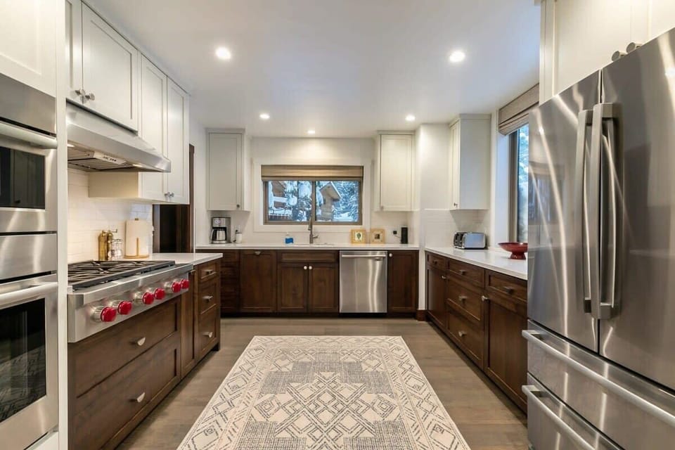 The fully equipped kitchen features top-of-the-line stainless steel appliances such as the 36” Wolf stovetop range, beautiful cabinets and countertops, and a walk-in pantry.
