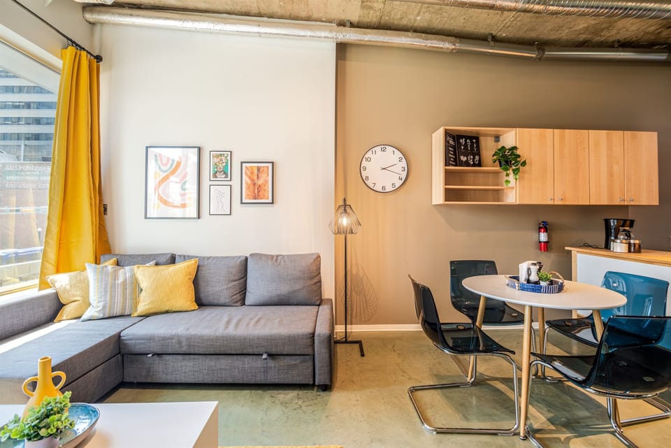 Bright and open living room with vibrant modern decor, featuring a sofa bed for an extra guest or couple