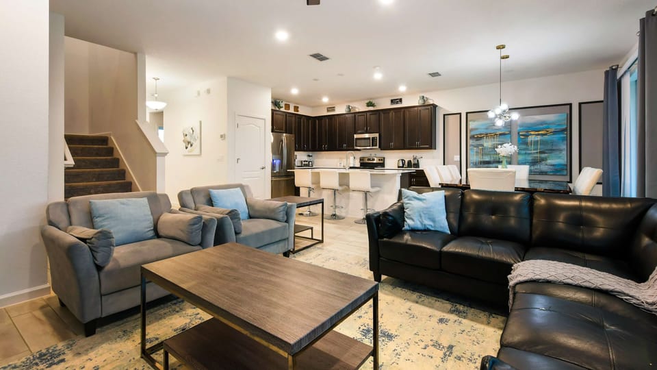 Spacious open-concept home with modern decor, cozy seating, and a full kitchen.