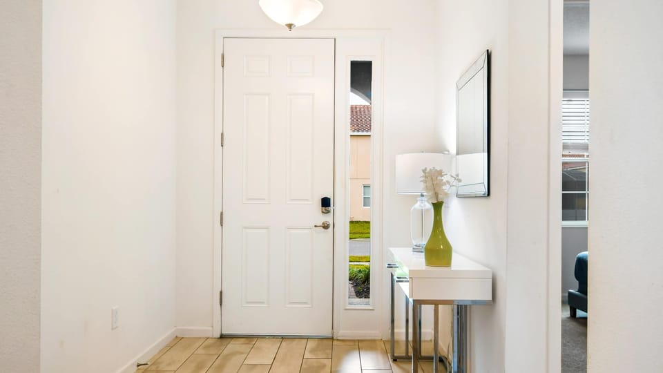 Bright and modern entryway with sleek decor, a stylish console table, and warm lighting.
