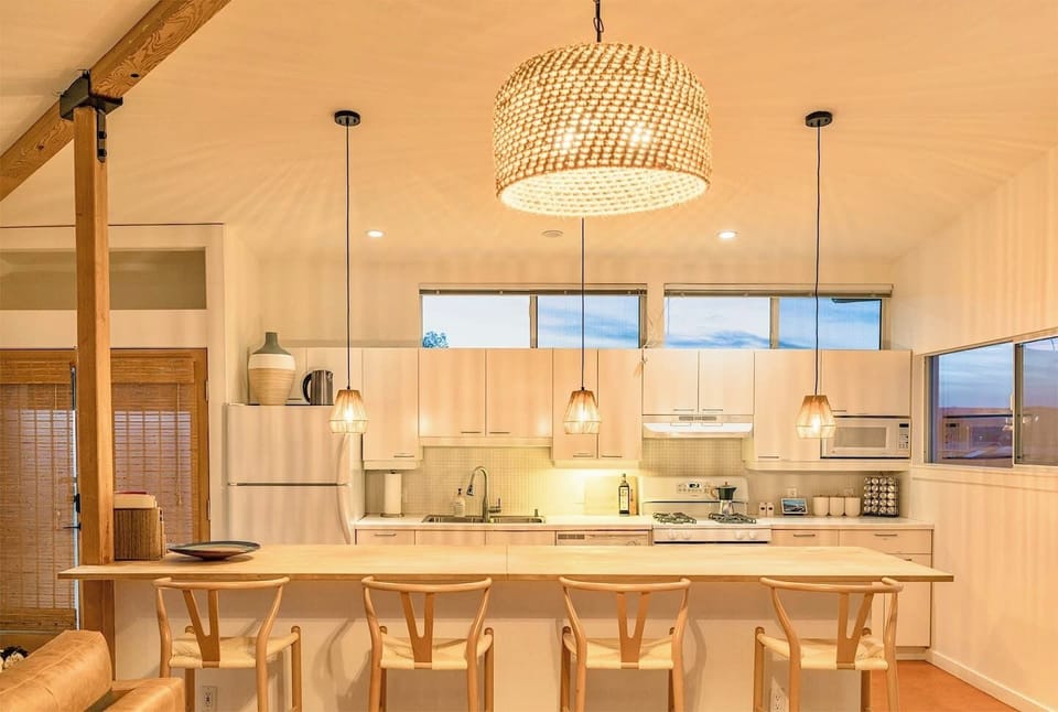 Modern open kitchen and dining area at Casa Altura Joshua Tree vacation rental with large island seating.