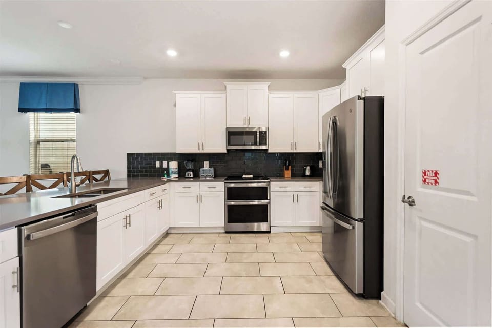 Spacious modern kitchen with sleek appliances and ample counter space, ideal for cooking family meals in style.