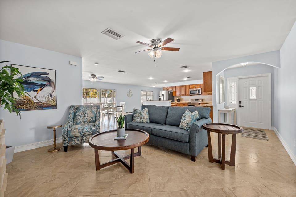 Open concept living, dining and kitchen open up to lanai and pool