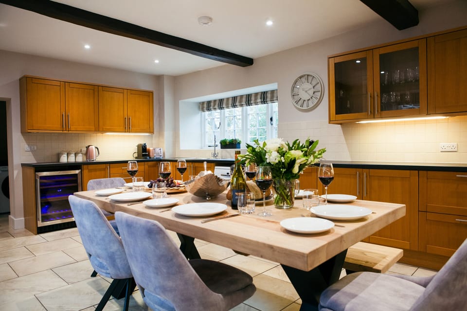 Kitchen/dining room with wine fridge and dining table seating eight guests