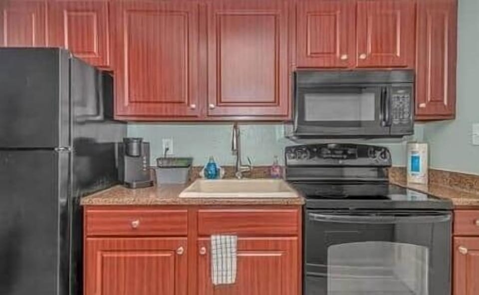 Well-equipped kitchenette featuring full-size appliances, Keurig, stove, and plenty of storage.