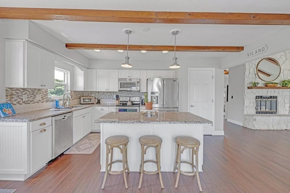 - Open layout connects the spacious kitchen to the cozy fireplace lounge
- Crisp design, granite surfaces, and wood accents create warmth and style
- Great space for entertaining with effortless flow from kitchen to seating