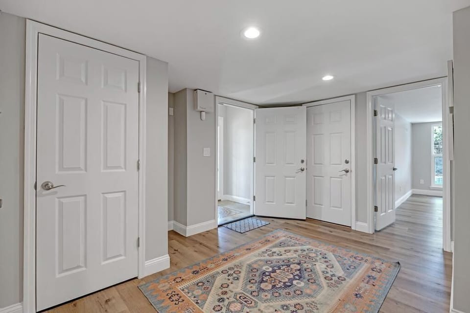 - Welcome home to this bright hallway with natural wood flooring, white trim, and multiple entry points
- Classic area rug grounds the space with warmth and style
- Recessed ceiling lights keep the hallway well lit and inviting