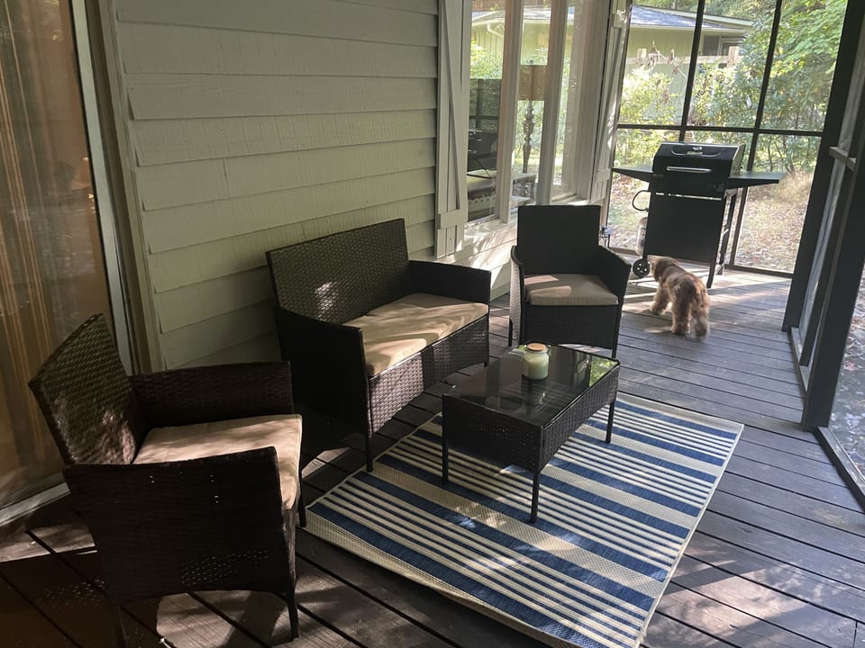 Outdoor screened porch has sitting area, grill and outdoor table (not shown) 