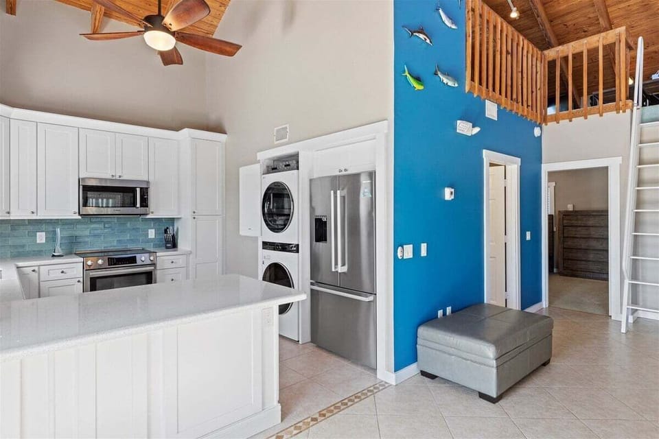 Airy elegance: Open-concept living, kitchen, and dining area beneath soaring ceilings.