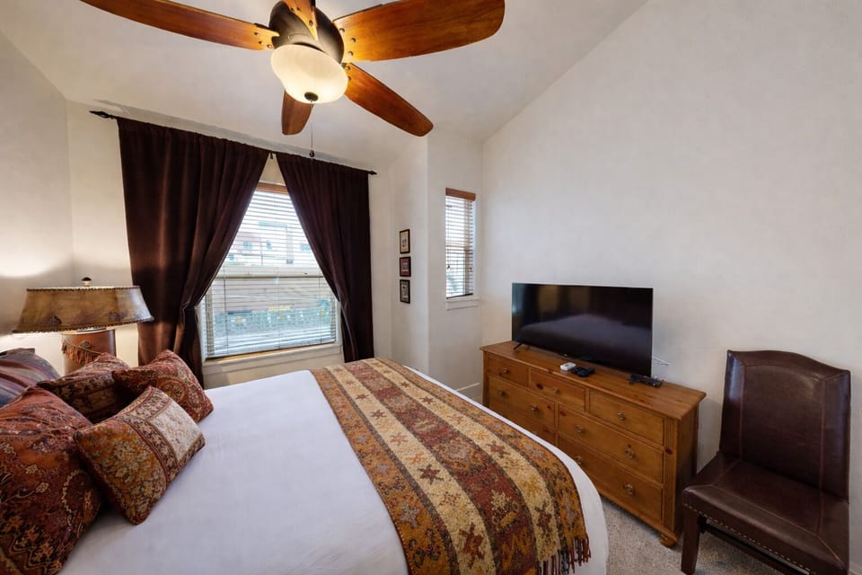 Unwind in this spacious and modern guest room featuring a plush queen bed and rustic wood accents. A bright, inviting retreat designed for ultimate comfort and relaxation.