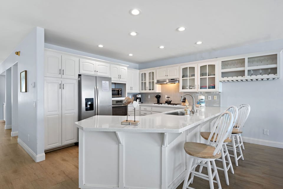 Fully equipped with sleek appliances and a spacious island, this kitchen is designed for cooking, gathering and making memories