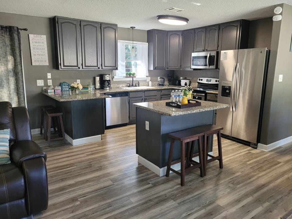A cozy kitchen/ dining room combo with island and  4 stools.
