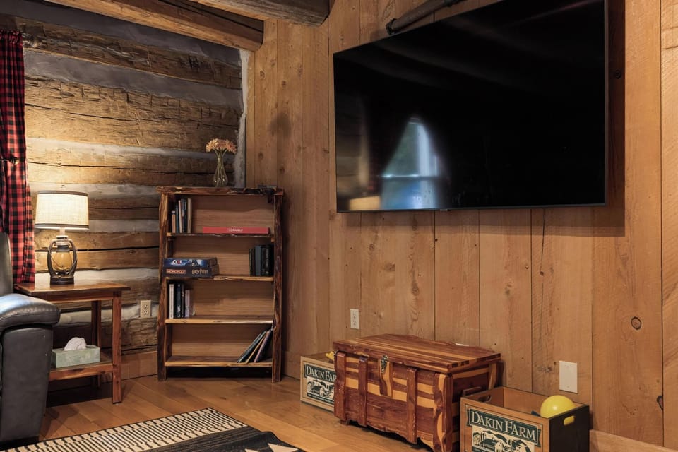 Cozy cabin-style lounge with rustic wood finishes and a large smart TV