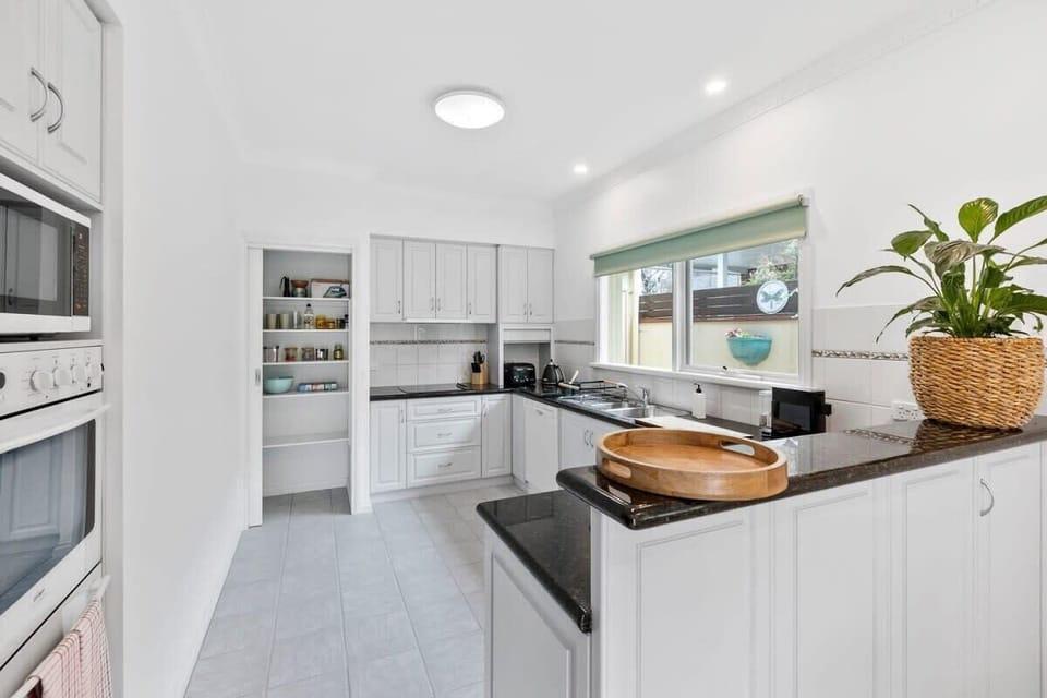 The kitchen’s fresh white coastal aesthetic complements the relaxed vibe of the home