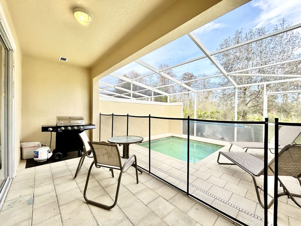 Broad view of the beautiful private pool area with a barbecue grill.